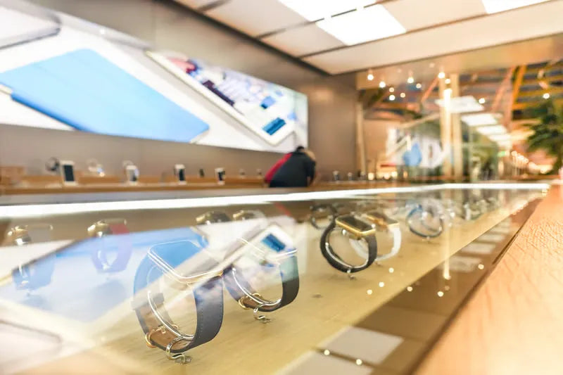 Smartwatches lined up in a glass display case in a tech store